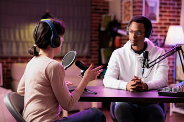 African american podcast host discussing with guest during live broadcast for social media website, listening to her story. Internet star using professional equipment to record chat