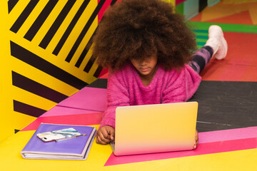 Happy african american black preteen school girl studying in classroom sitting at desk. Smart cute...