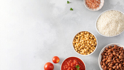 Ingredients for healthy vegan dish cooking on grey table. Copy space