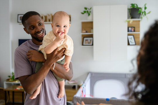 African American father holding his baby at home