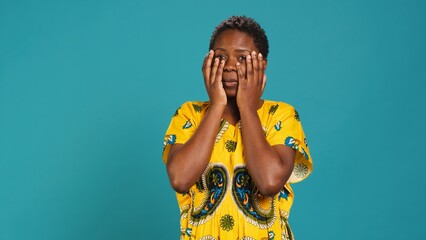 Horrified young woman covering her eyes to avoid seeing something, feeling squeamish and appalled...