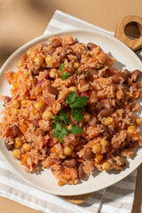 Jambalaya with rice chickpeas and kidney beans on beige table
