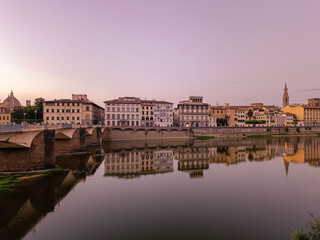 Obraz premium Buildings reflected with water blur in the river Arno and bridge alle Grazie at evening, Florence ITALY