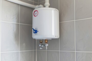 A water heater installed on a wall in a bathroom, providing hot water for household use