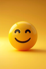Fototapeta premium A yellow smiley face emoticon with a happy expression on a yellow background