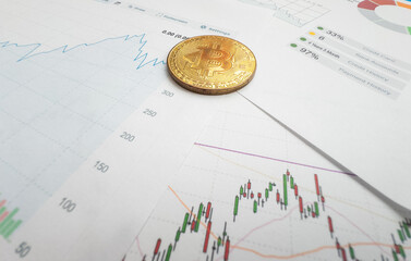 Bitcoin coin is on background of stock chart