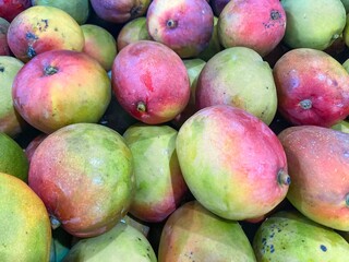 Pile of fresh mangoes on Brazilian market stall for sale.