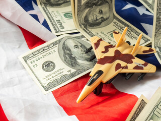 Background of one hundred dollar bills with model fighter airplane 