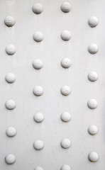 Riveted with button-head rivets metal plate painted in white as an industrial background
