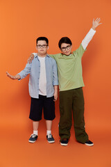 Two young boys, one with Down syndrome, stand together at home.