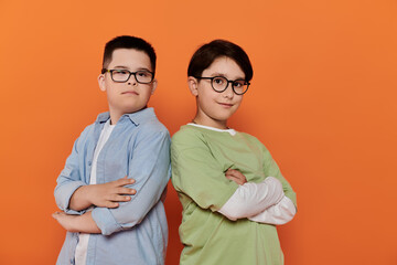 Two boys, one with Down syndrome, stand side-by-side against an orange background.