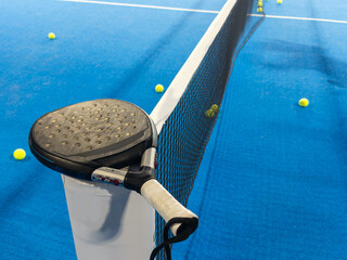 paddle tennis racket and balls on the blue paddle court