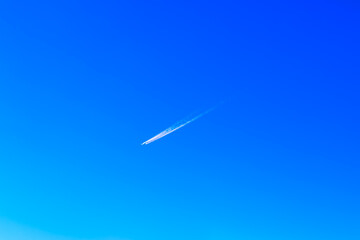 Airplane trail in the blue sky, aircraft trail in the blue sky.  Jet plane soaring through a clear blue sky