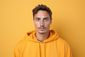Fototapeta premium A man in a yellow hoodie is looking at the camera