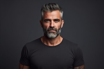 Obraz premium A man with a beard and gray hair is wearing a black shirt
