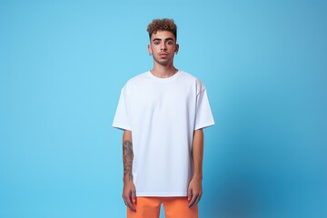 A man in a white shirt stands in front of a blue background