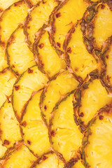 Pineapple juicy yellow slices background. Top view.