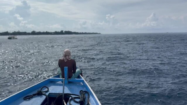 Un pescatore sulla poppa della barca