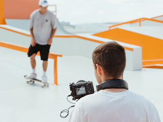 Videographer filming skateboarding in skatepark © fascinadora