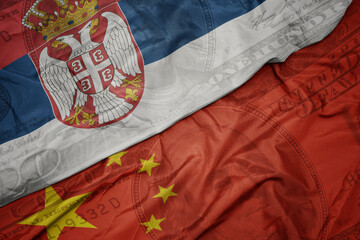 waving colorful flag of serbia and national flag of china on the dollar money background. finance concept.