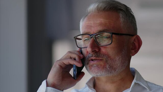Close up Caucasian mature businessman talking mobile phone business discuss conversation negotiate distant speaking with smartphone in office senior man talk answer call.