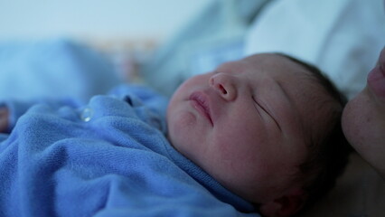 Newborn baby sleeping soundly, wrapped in a blue outfit, capturing the peacefulness and purity of early days, emphasizing the calm and tranquil nature of a sleeping infant