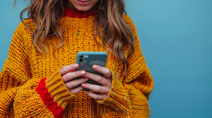 In an extreme close-up, a woman's hands navigate her smartphone against a blue background. Her fingers click the screen, highlighting social media, text messaging, and web browsing.