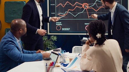 Marketing team attending a tensed meeting to review sales trends on interactive board, looking for ways to increase the organization profit and ensure global success. PR specialists. Camera A.