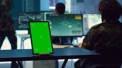 Isolated greenscreen display running on a tablet in military power base, soldiers follow...