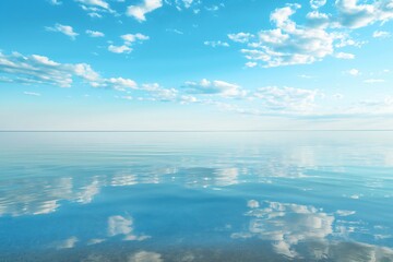 Fototapeta premium Tranquil beach scene with calm, crystal-clear water reflecting a beautiful sky dotted with fluffy clouds at the horizon