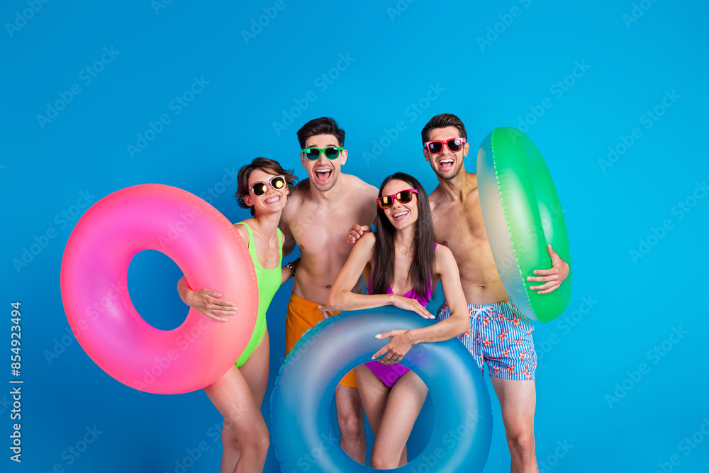 Wall mural photo of carefree excited fellows company wear swimsuits enjoying pool party isolated blue color bac