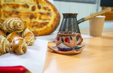 Armenian cuisine, still life, beautiful ceramic coffee cup, cezve, pastries and bread, focus on the cup