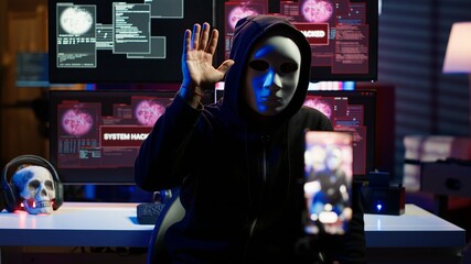 Hacker concealing identity filming ransom video in hidden underground base, threatening to release...