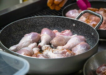 Pans with chicken meat stand on the stove, frying chicken, cooking, real picture in the kitchen