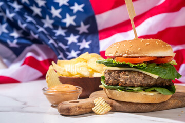 Tasty cheeseburger, chips and sauce with patriotic american flag