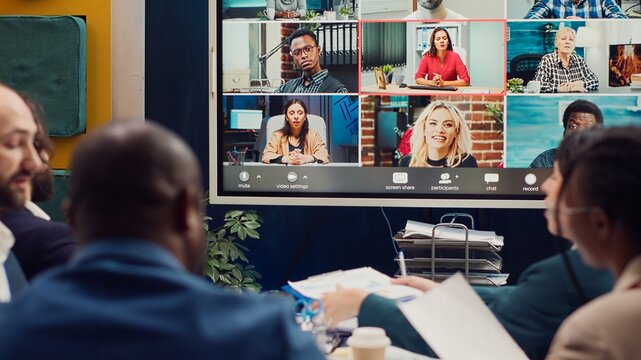 Business associates meeting with stakeholders on a videocall connection, sharing insight and updates on a new development project. Executive board members discussing about firm growth. Camera A.