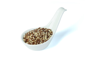 Dried two quinoa seeds, red and white, in white ceramic spoon isolated on white background top view flat lay. Super functional food , healthy eating, super food concept.