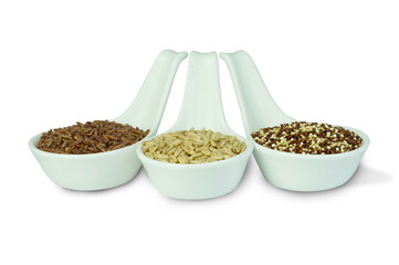 Group of quinoa seeds, raw oat and red brown rice in white ceramic spoons isolated on white background top view flat lay. Super functional food , healthy eating, super food concept.