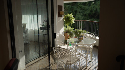Cozy Balcony Setup with Plants and Furniture in Sunlit Ambiance
