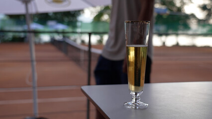 Elegant Glass of Sparkling Wine on Outdoor Patio Table - Refreshing Drink Scenery