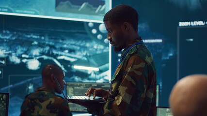Military sergeant targeting enemy vessels on a gps satellite world map, operating from army power...