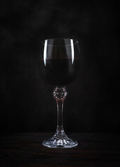 A glass of red wine in dark background