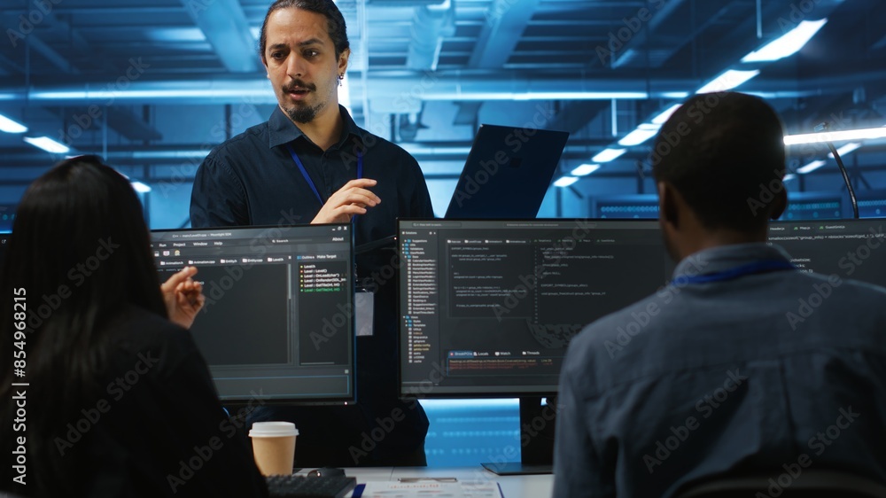 Poster manager and it support specialists working together, supervising server rows in computer network sec