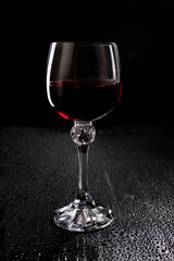 Glass with red wine on a black background.