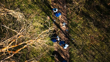 Aerial view of campaigners joining forces to recycle and tidy up garbage in a forest in order to...