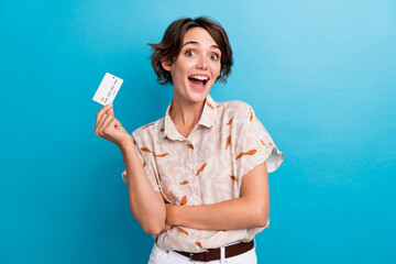 Photo of nice astonished person open mouth arm hold showing plastic debit card isolated on blue...