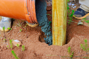 Construction of new timber fence and wooden fence posts using concrete
