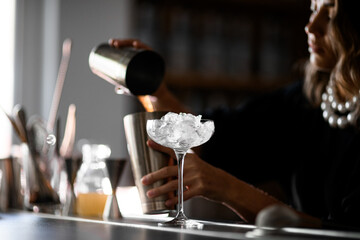 Focus on a glass on a tall stem filled with pieces of ice