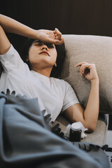 Cold medicine and sick woman drinking hot beverage to get well from flu, fever and virus. Dirty paper towels and tissues on table. Ill person wearing warm woolen stocking socks in winter.