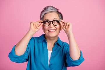 Photo portrait of attractive senior woman look empty space touch specs dressed stylish blue clothes...